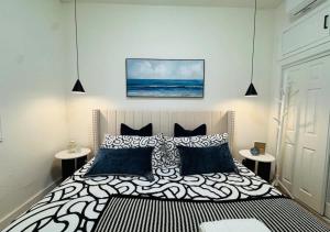 ein Schlafzimmer mit einem Bett mit schwarzen und weißen Kissen in der Unterkunft #Marbella Lane - Stylish Haven Near City Center in Long Beach