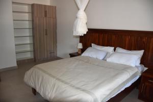 Un dormitorio con una cama grande con sábanas y almohadas blancas. en Tabonina Apartments, en Livingstone 18 fotos más