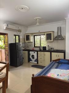 a large kitchen with a bed in a room at Goaesha Apartment in Calangute