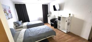a hotel room with two beds and a television at Ferienwohnung FeLu in Wadgassen