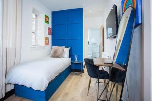 a bedroom with a bed and a desk with a surfboard at Luxury Guesthouse by The Hive WA1 in Warrington