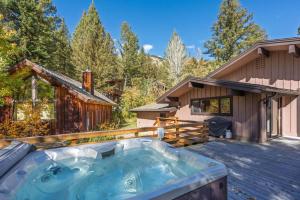 a hot tub on a deck next to a house at Bray House - Ski-in Ski-out family home in Teton Village
