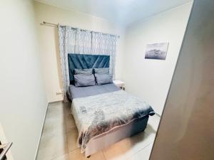 a bedroom with a bed with a blue headboard at Waterfall Bay in Midrand +23 photos