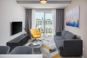a living room with a couch and a tv at Maj Luxury Residence in Poreč