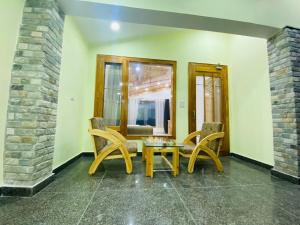 a dining room with two chairs and a table at Apple Flower Hotel - Personal Balcony, Lift, Garden and Mountain View in Manāli