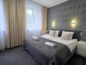 a bedroom with a large bed with two towels on it at Hotel Orbita in Wrocław