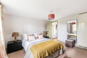 ein Schlafzimmer mit einem großen Bett und einem Spiegel in der Unterkunft Pelsham Farm Cottage in Peasmarsh