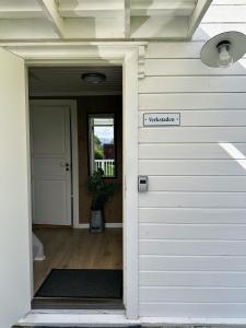 a door to a house with a sign on it at Koselig vestlandshus ved fjorden in Holmedal
