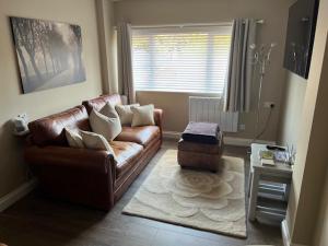 a living room with a leather couch and a rug at Luxury Guest Suite Dog Friendly in North Scarle