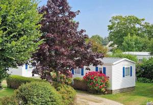 a white house with blue windows and a tree at Camping 3 étoiles - ccbc0hb in Pordic