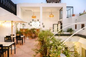 an outdoor patio with tables and chairs and plants at Riad la Parenthèse by Sashema in Marrakesh