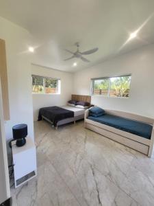a bedroom with two beds and a ceiling fan at Te Aro Villa 3 brand new 5 brm villa with pool in Titikaweka