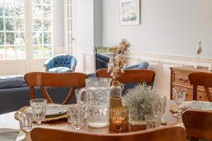 a dining room with a table with glasses on it at Le Clos Bleu du Lac - Charmante location tout proche du lac d'Annecy avec jardin in Saint-Jorioz