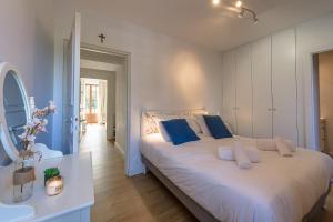 a bedroom with a large white bed with blue pillows at Le Clos Bleu du Lac - Charmante location tout proche du lac d'Annecy avec jardin in Saint-Jorioz
