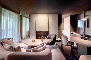 a living room with a couch and a fireplace at AMONTI Chalets in Molini di Tures