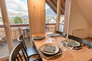 Un comedor con una mesa con copas de vino. en Le Tournette - Appt 1 chambre, balcon vue montagne, en Saint-Jorioz
