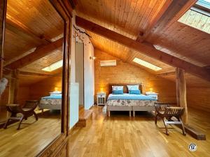 una camera con due letti in una stanza con soffitti in legno di Le Lion de Venise a Saulon-la-Rue