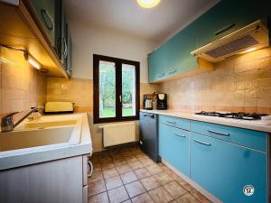 una cucina con mobili blu e un lavandino di Le Lion de Venise a Saulon-la-Rue Altre 29 foto