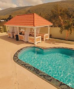 a swimming pool with a gazebo next to a house at Private Villa Paradise - Pool & Mountain Views in Top Hill