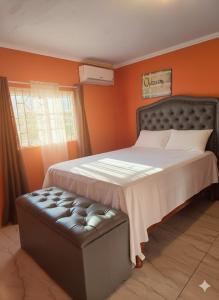 a bedroom with a large bed with an orange wall at Private Villa Paradise - Pool & Mountain Views in Top Hill