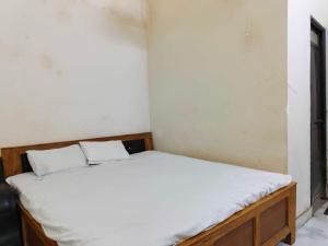 a small bedroom with a bed with white sheets at Hotel O Bihar Sharif Railway Junction Formerly Shree Balajee in Bihār Sharīf