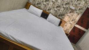 a bed with white sheets and two pillows at Hotel O Bihar Sharif Railway Junction Formerly Shree Balajee in Bihār Sharīf +14 photos