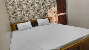 a bed with two white pillows on top of it at Hotel O Bihar Sharif Railway Junction Formerly Shree Balajee in Bihār Sharīf