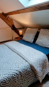 a bedroom with a bed and two pillows at Au Nid Douillet in Gilocourt