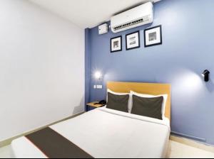 a bedroom with a white bed and a blue wall at Townhouse Golkonda Fort Formerly Hotel Langar Houz in Haidar Sāhibgūda