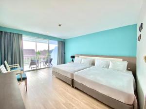 a bedroom with a large white bed and a balcony at Pinnacle Grand Jomtien Resort and Beach Club in Na Jomtien