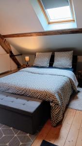 a bedroom with a large bed with a skylight at Au Nid Douillet in Gilocourt