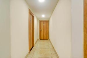 a hallway with a door and a tile floor at Townhouse Oak City Centre Dhanbad Formerly Hotel Kuber Inn in Dhanbād