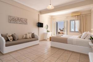 a bedroom with two beds and a couch at Elea Sun Hotel in Kamari