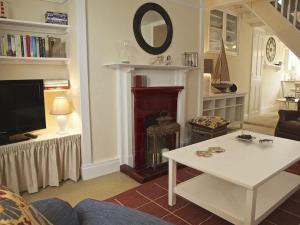 sala de estar con mesa blanca y chimenea en St Leonards, en Salcombe