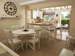 Una cocina y un comedor con mesa y sillas. en St Leonards, en Salcombe