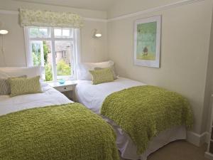 Dos camas en una habitación con ventana. en St Leonards, en Salcombe