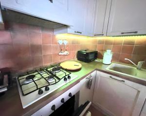 a kitchen with a stove and a sink at Villa La Dolce Vista & Jacuzzi in Costa Paradiso