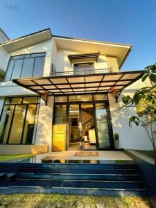 a house with glass doors and stairs in front at AnAn VILLA in Khu Chi Lăng