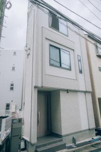 a white brick building with a door at Metronest 三軒茶屋 in Tokyo
