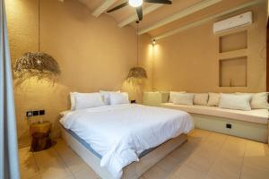 - une chambre avec un grand lit blanc et un banc dans l'établissement Mexican One Bedroom, à Mantaak