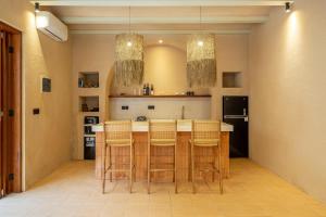 une cuisine avec un îlot doté de chaises et d'un comptoir dans l'établissement Mexican One Bedroom, à Mantaak