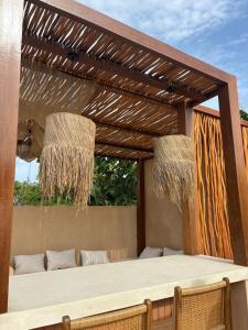 une pergola avec un canapé sur une terrasse dans l'établissement Mexican One Bedroom, à Mantaak