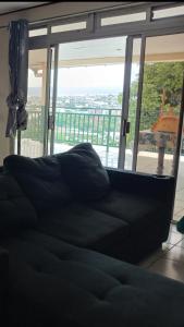 a black couch in front of a large window at Night Inn in Papeete