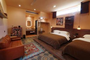 a hotel room with two beds and a couch at DunHuang FengMingSha Hotel in Dunhuang