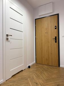Habitación vacía con puerta y suelo de madera en Apartament OMEGA, en Nysa