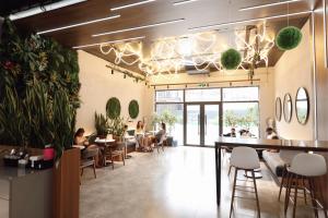 a restaurant with people sitting at tables and a bar at Come a Lot Aparthotel Batumi in Batumi