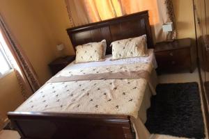a bedroom with a large bed with a wooden headboard at 2-Bed - Sleeps 6 - Pet Friendly & Parking in Brusubi