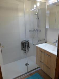 a shower with a glass door next to a sink at Floréa 8 in La Clusaz