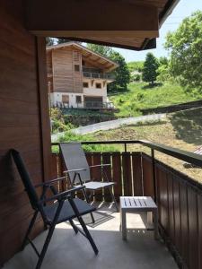 a balcony with a chair and a bench and a house at Floréa 8 in La Clusaz