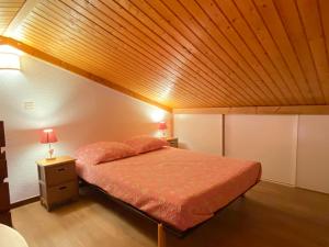 a bedroom with a bed with a wooden ceiling at Floréa 8 in La Clusaz